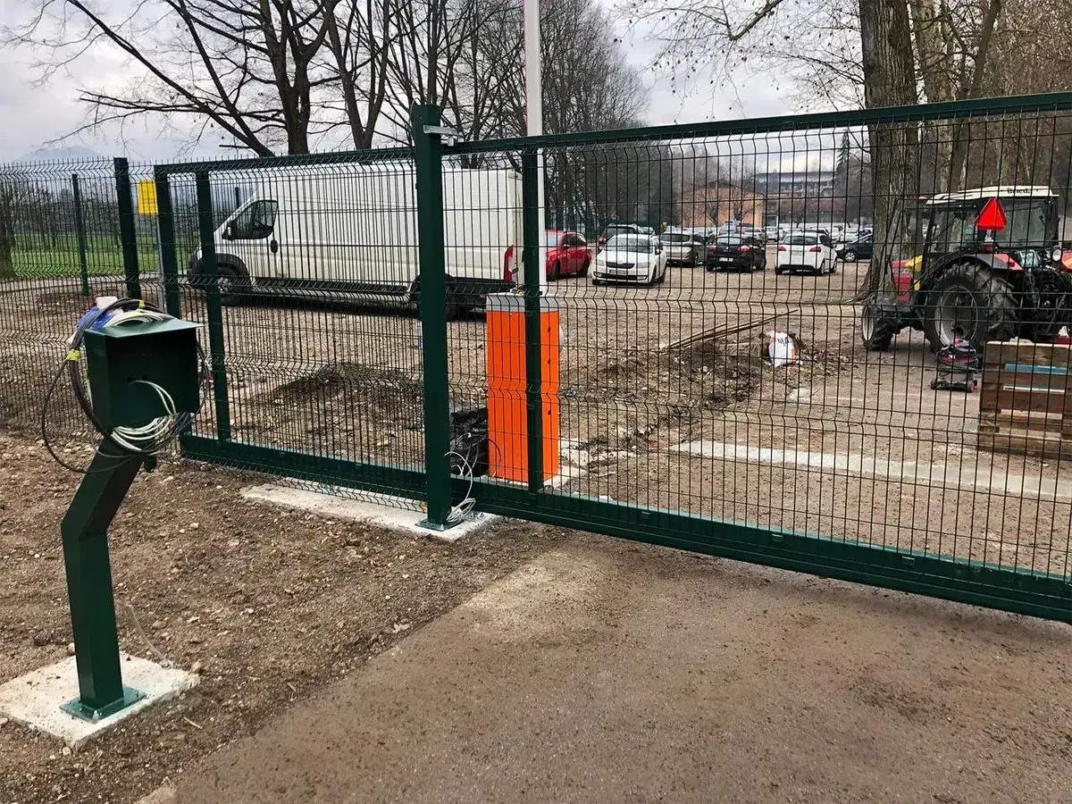 Zelena panelna ograja z drsnimi vrati in zapornico